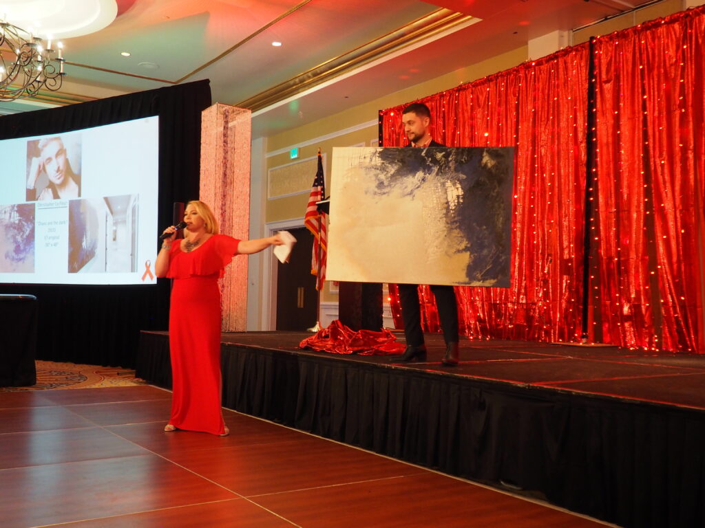 Auctioneer presents large painting for live auction